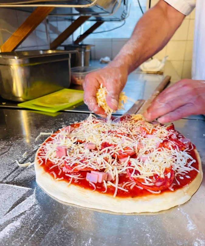 Garniture d'une pizza avant cuisson