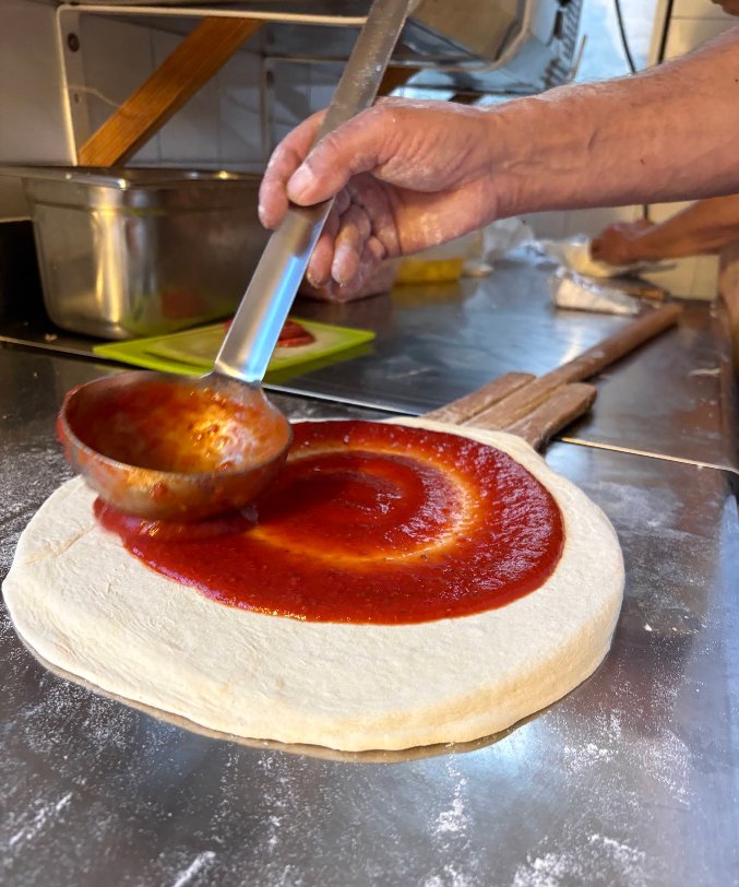 La sauce tomate étalée sur la pâte